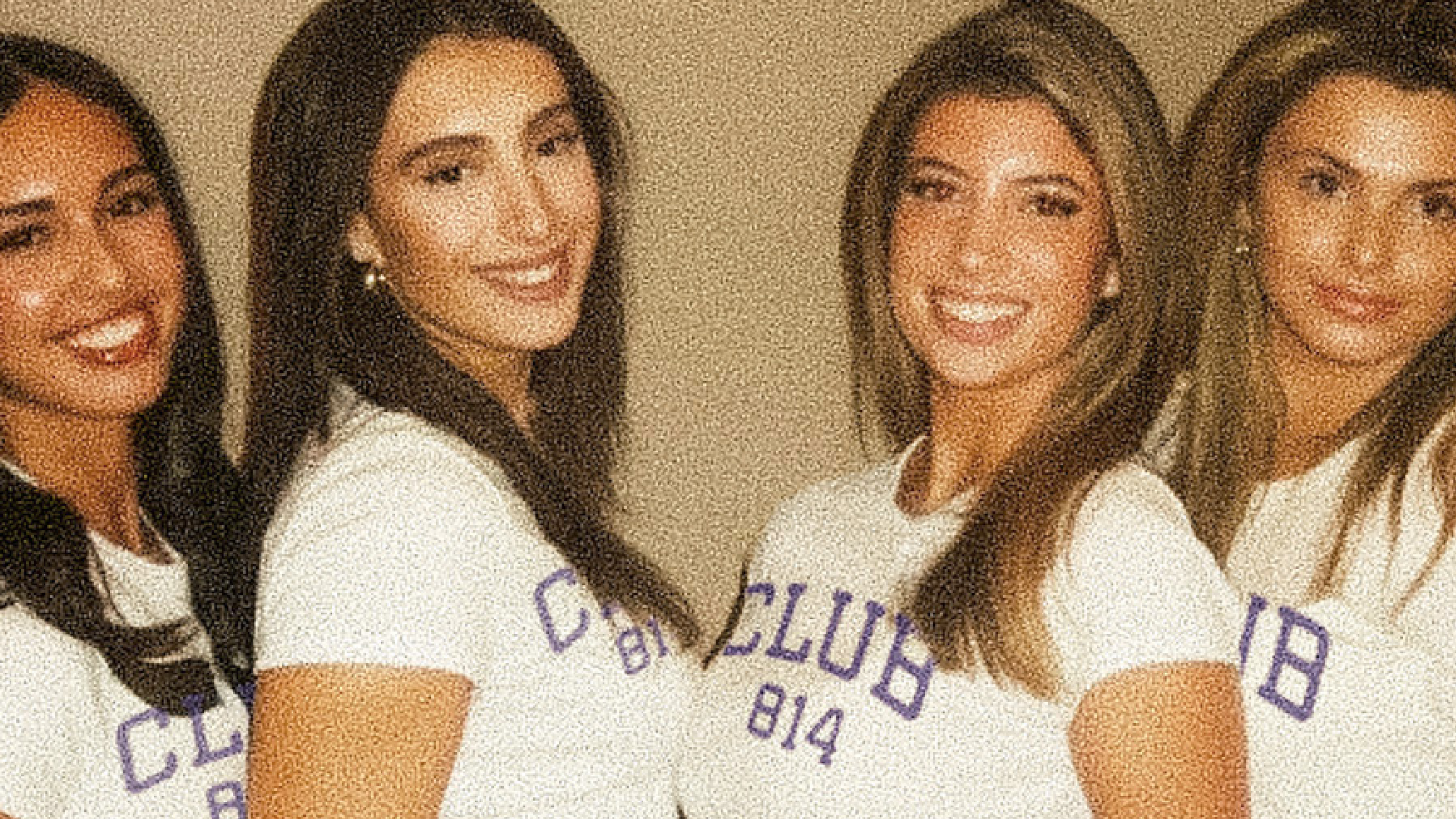 Four young women standing together and smiling, wearing matching white t-shirts with purple collegiate-style lettering that reads 'CLUB 814' and blue jeans.